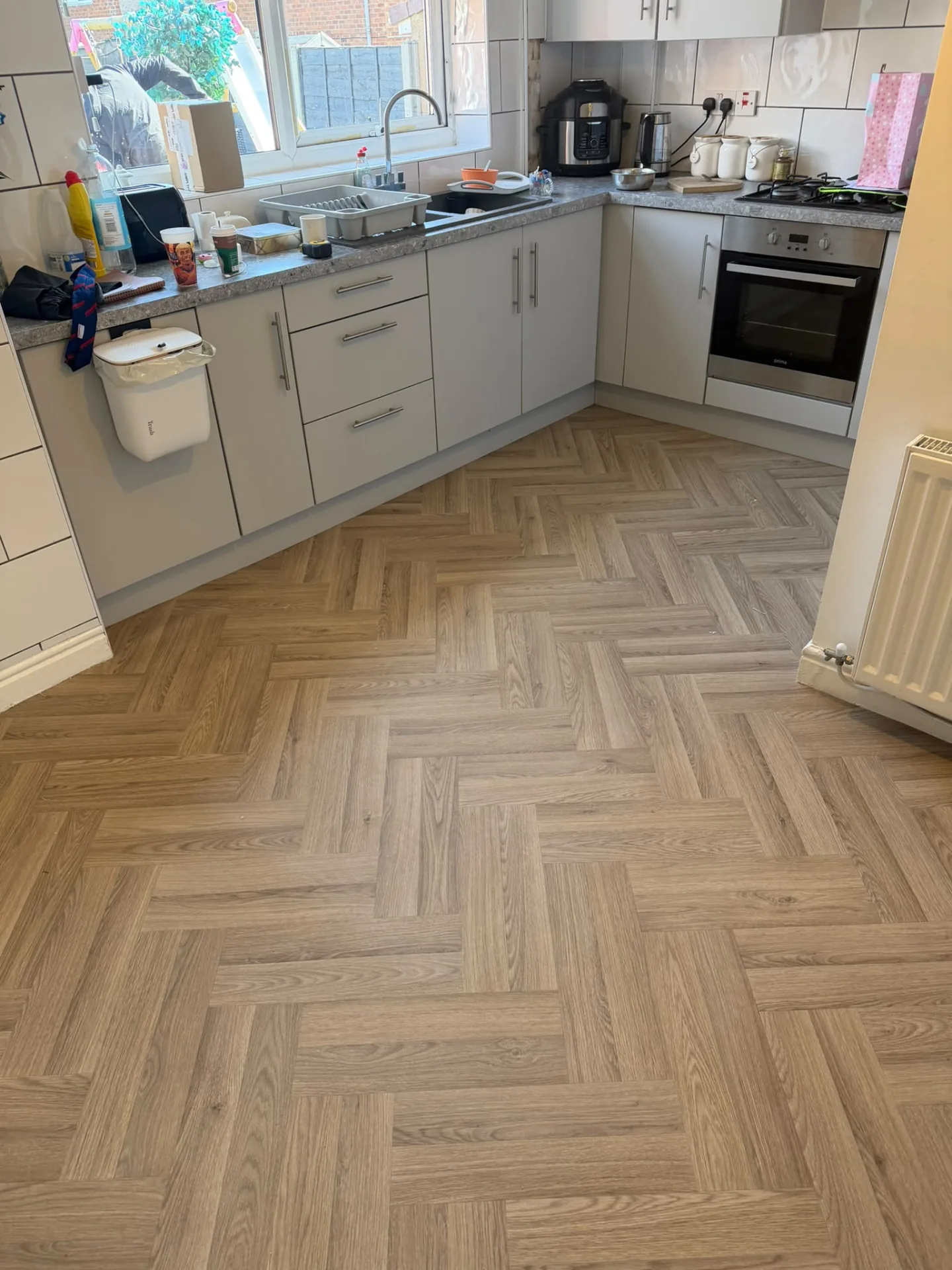 Light oak herringbone vinyl flooring fitted in a kitchen, Signature Carpets and Flooring, Greater Manchester