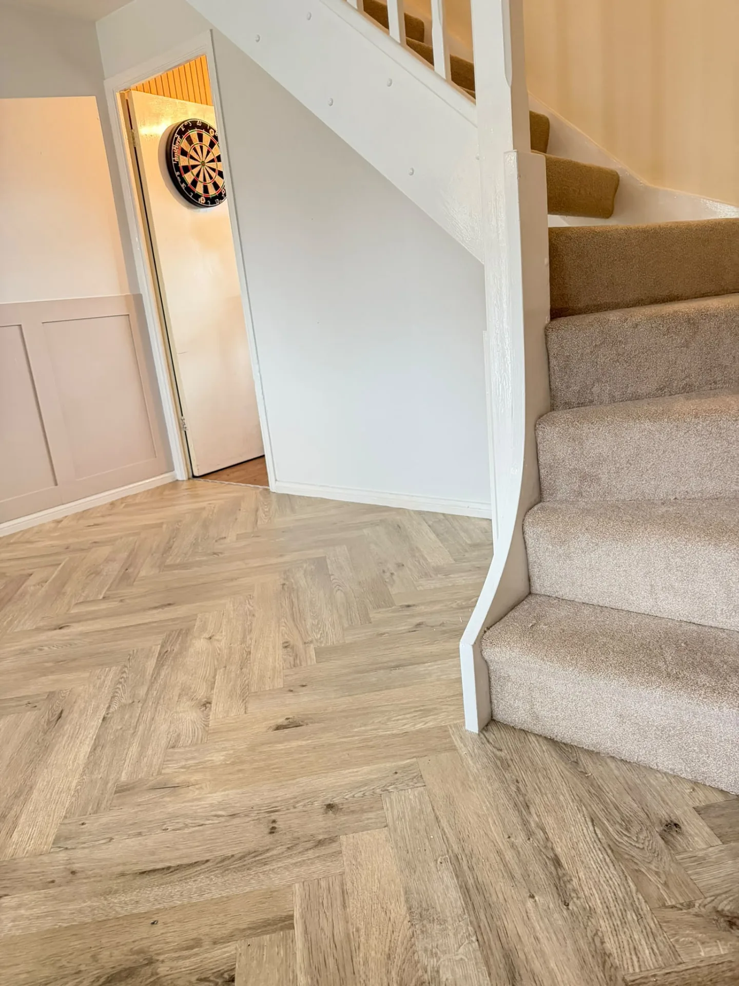 Light oak herringbone LVT fitted in a hallway beside the stairs, Signature Carpets and Flooring, Greater Manchester