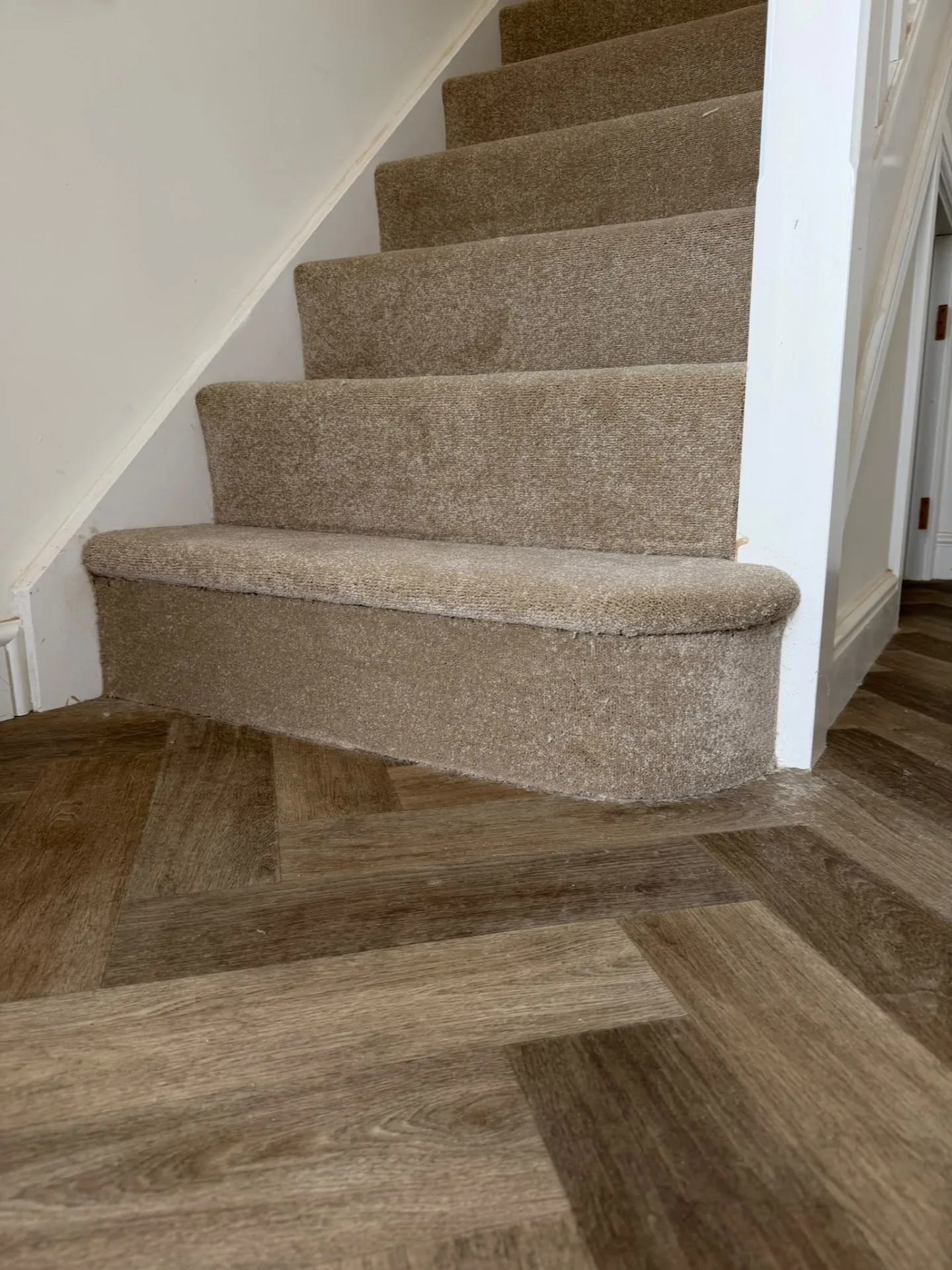 Carpeted bullnose stair meeting wood-effect flooring, Signature Carpets and Flooring, Greater Manchester