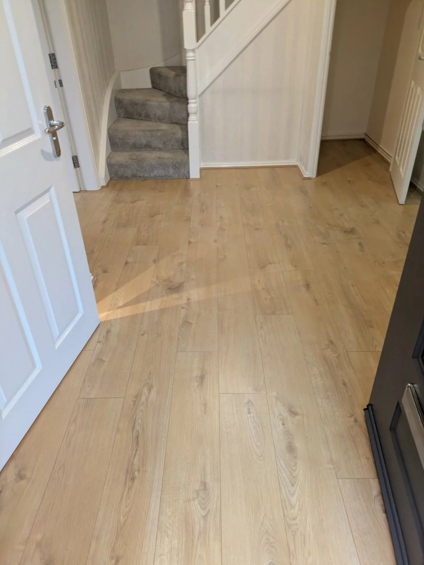 Oak-effect laminate flooring fitted in a hallway, Signature Carpets and Flooring, Greater Manchester