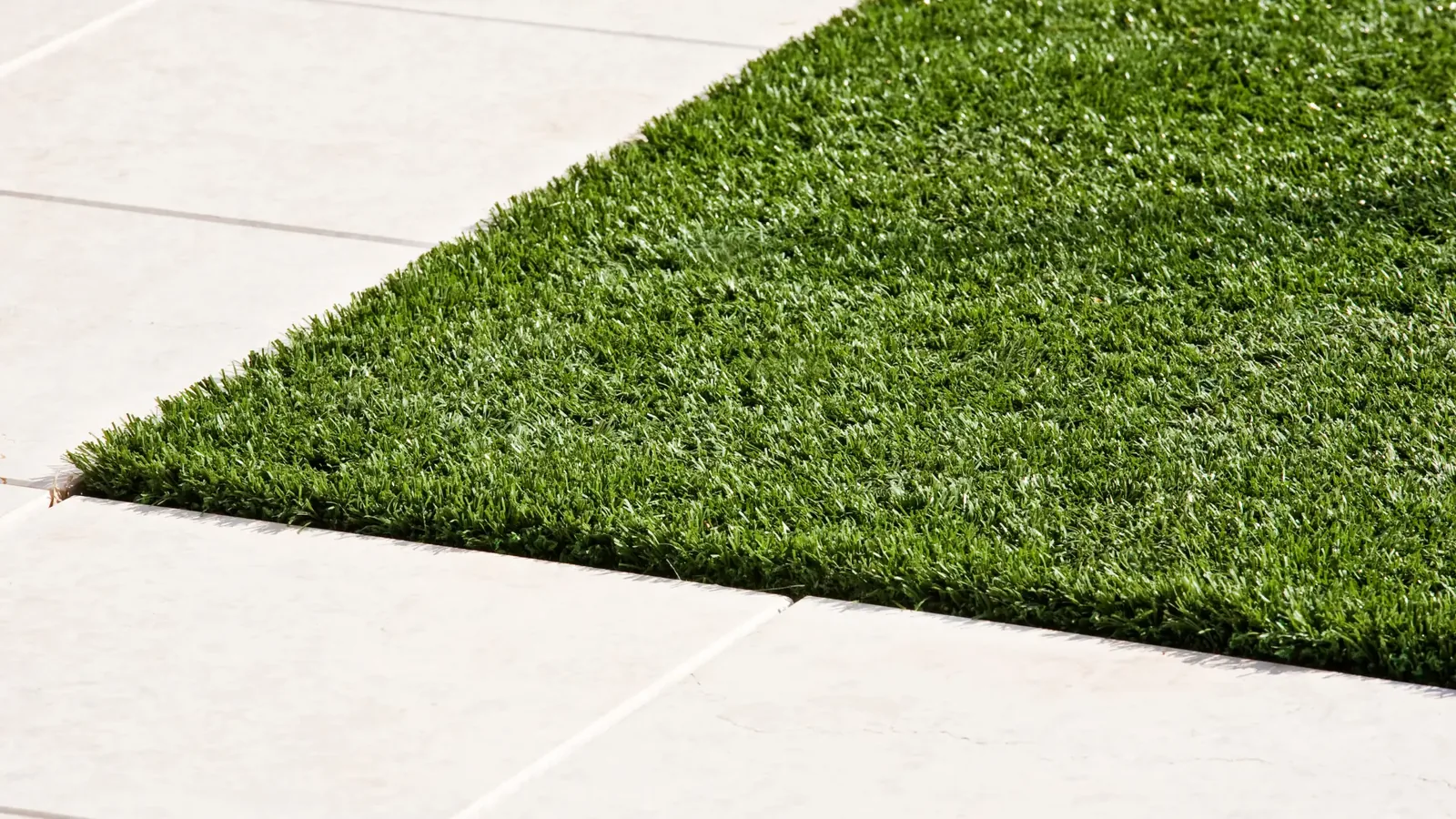Artificial grass laid neatly alongside paving, Signature Carpets and Flooring