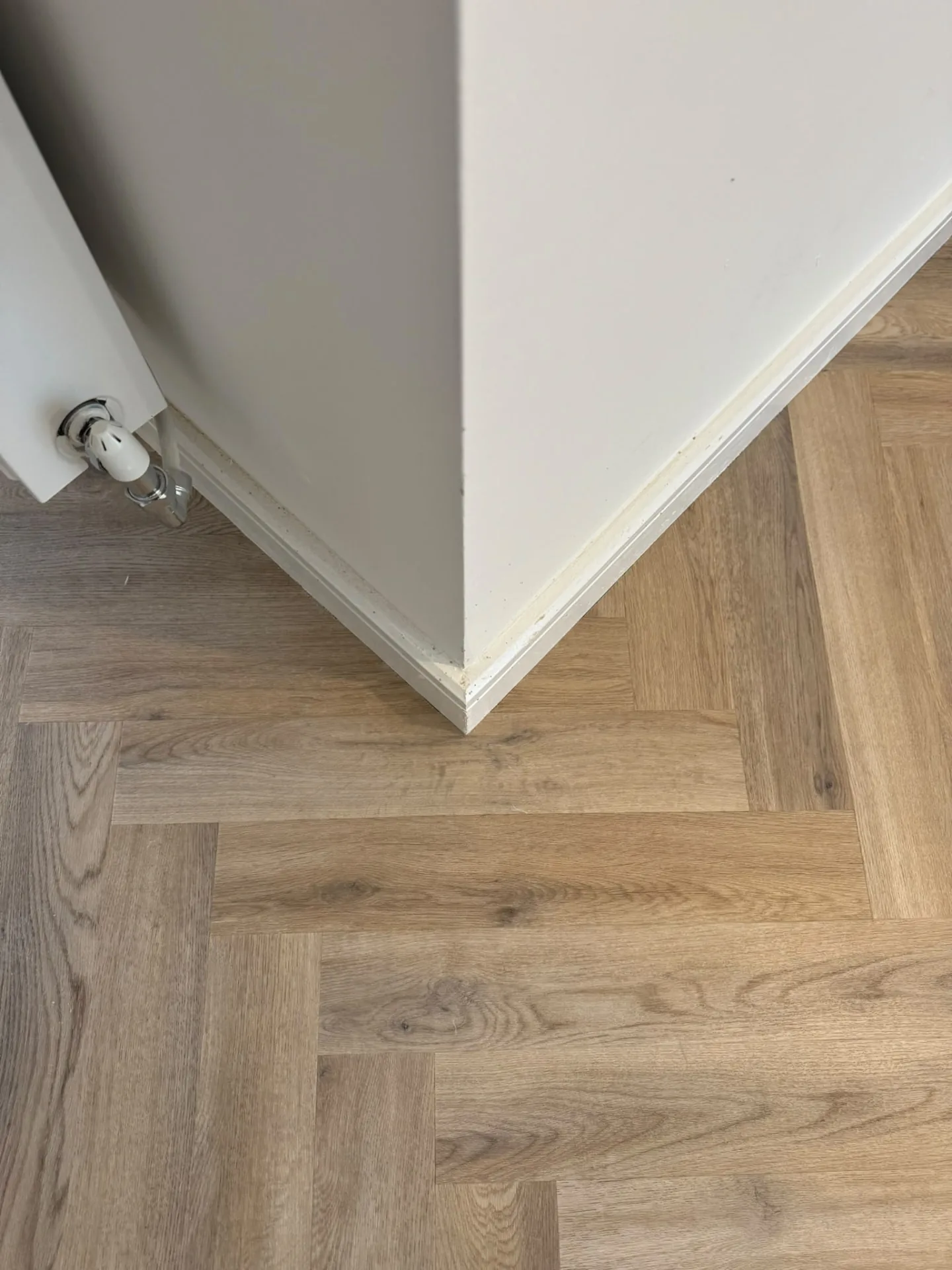 Close-up of herringbone LVT fitted to a wall corner, Signature Carpets and Flooring, Greater Manchester